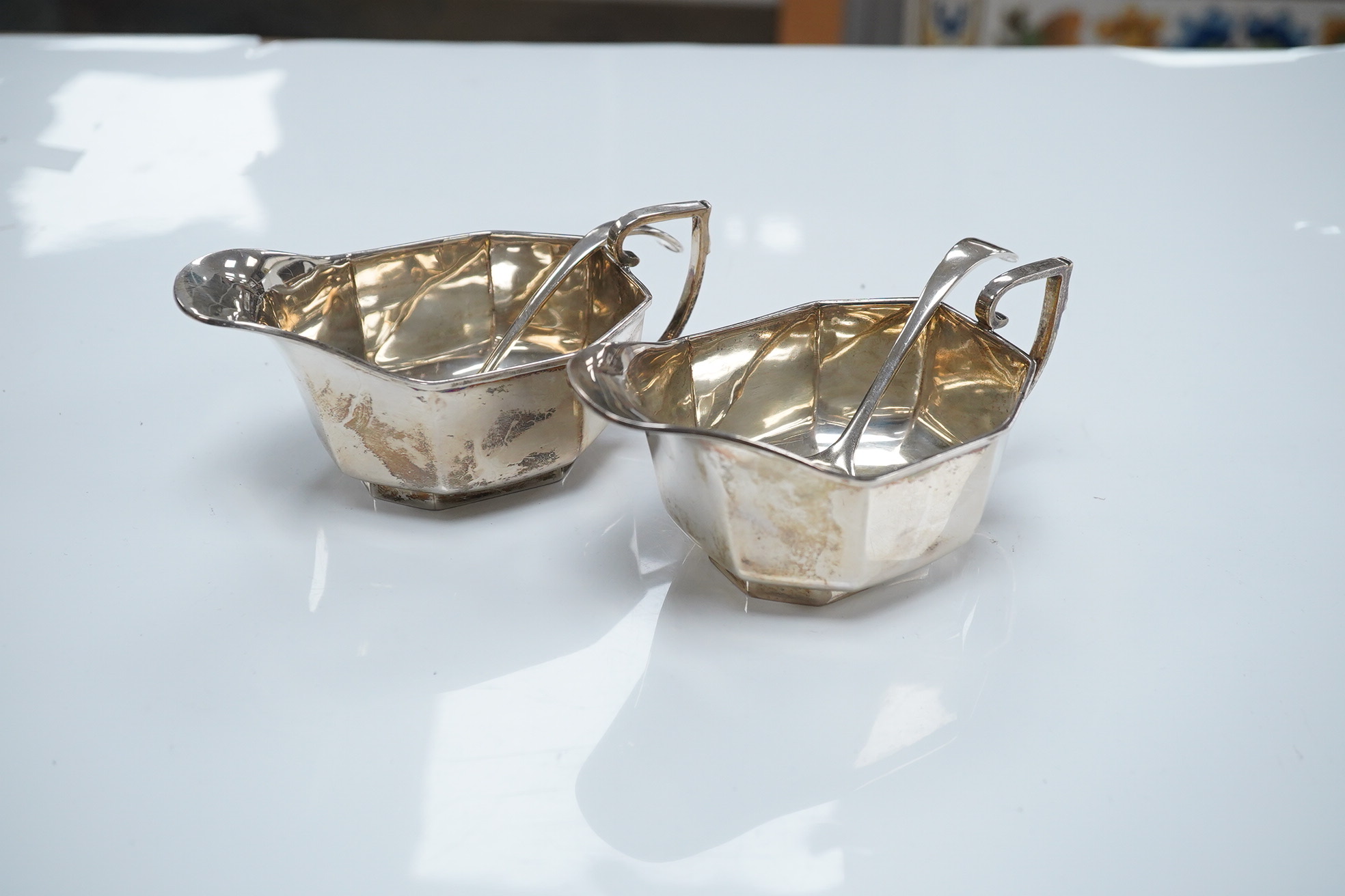 A pair of George V silver sauceboats, Henry Clifford Davies, Birmingham, 1936, length 13.4cm, together with a later pair of sauce ladles by Cooper Brothers & Sons, 9.1oz. Condition - fair to good